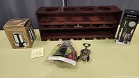 Photo showing wooden wine rack, Italian stovetop espresso maker in box, Vinturi wine aerator boxed, metal corkscrew, and assorted wine stoppers