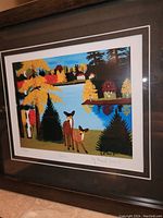 Framed fine art print titled 'Deer' by Maud Lewis showing two deer near a lake with colorful autumn trees.