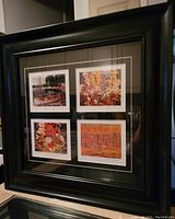 Framed set of four Tom Thomson prints in a black wooden frame with double white mat.