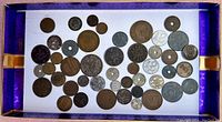 Top view of all coins showing size and color variety in a box