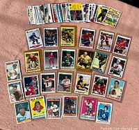 Wide view showing a large spread of assorted sports cards, mostly hockey and baseball players, some with colorful and vintage designs.