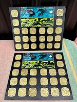 Full photo showing two coin holders, each with 27 coins and bilingual headers for indoor and outdoor Olympic events by Sunoco from 1972 promotion in Canada.