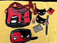 Top-down view of all Emily the Strange items including two bags, two plush cat purses, wristwatch, keychain, and a small wallet/cardholder