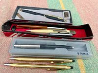 Overview of pens and pencils including boxed Sheaffer Ritepoint pen and Parker pen, two gold-tone pens.
