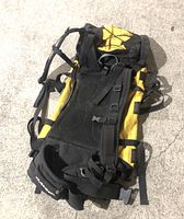 Front and side view of Dakine Blade black and yellow backpack showing straps and padding