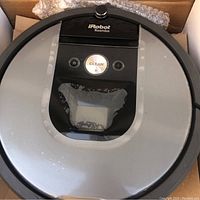 Top view of iRobot Roomba vacuum cleaner showing the central 'Clean' button and transparent dustbin area.