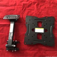 Photo showing the main mounting plate and arm of the TV wall mount on a red background.