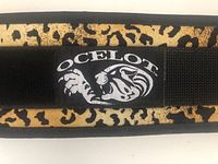 Close-up of the Ocelot logo patch on the weight belt showing leopard head design and branding.