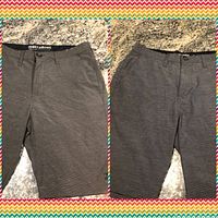 Front views of two pairs of gray Billabong Crossfire Submersible shorts with button closure and belt loops.