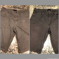 Two pairs of men's shorts laid flat, one grey patterned and one black denim.