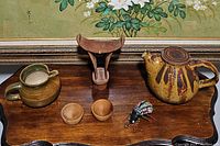 Overview of all items on a wooden surface with a framed painting in the background.