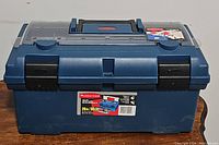 Closed Rubbermaid toolbox showing blue body, black latches, and clear plastic top compartments.