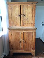 Front view of two-piece wooden hutch showing upper and lower cabinets with four panel doors