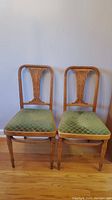 Pair of bentwood chairs side by side showing overall condition, wood detail and green upholstered seats