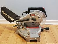 Full view of Craftsman mitre saw with dust collection bag attached showing overall condition and design.