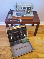 Both machines shown together: Singer 301 in case on floor and Kenmore on wooden bench