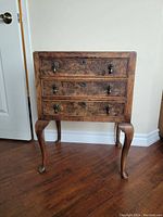 Front view showing full table with three drawers and cabriole legs