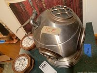Front side view of metal ice bucket with 'ICE' label and spout handle attached showing its vintage design and condition.