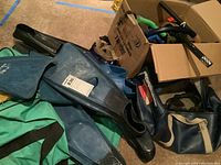 Photo showing dark blue snorkeling fins and other gear on green bag
