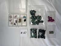Overview photo showing all gemstone bags and small white compartment box with various loose stones inside.