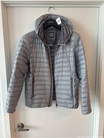 Front view of grey Geox Respira men's hooded puffer jacket hung on a hanger, showing full length, sleeves, hood and zippered pockets.