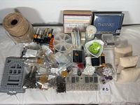 Full view of assorted jewelry making supplies and thank you card boxes laid out on a white surface.