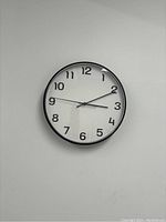 Front view showing the white face with black Arabic numerals and black hands.