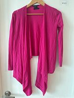 Bright pink open front Armani Exchange sweater on wooden hanger