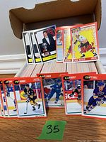 Lot of hockey cards in a cardboard box, showing player cards of Jeremy Roenick, Cam Neely, Brett Hull, Joe Sakic, and Felix Potvin