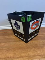 Side view of the hanging light showing Toronto Maple Leafs logo and Montreal Canadiens logo on opposite panels with clock displays at bottom