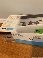 Box of Moen Boardwalk WS84820BRB bathroom faucet set showing brand, model, and price label