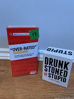 Front view of Over-Rated and Drunk Stoned or Stupid games showing titles and overall packaging condition.