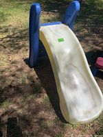 Side view of blue and white plastic children's slide showing dirt mark on the slide surface.