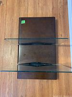 Overhead view of one shelf showing dark wood base with two vertical glass panels for organizing wires.