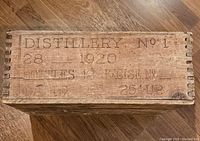 Top view showing 'DISTILLERY No. 1 28 1920' marking and bottle/excise details printed on the wood surface.