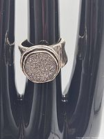 Front view of chunky brutalist style sterling silver ring showing natural quartz stone set in round bezel with textured, rugged band.