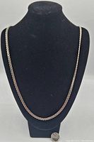 Full length view of the sterling silver chain necklace displayed on a black bust with a coin for size comparison.