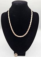 Front view of the sterling silver braided necklace displayed on a black bust stand.