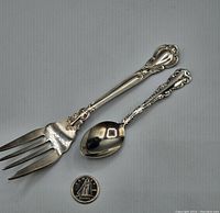 Pair of sterling silver Birks serving pieces shown next to a Canadian 50 cent coin for scale.