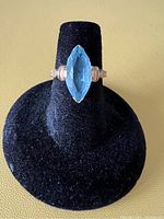 Front view of the ring showing the marquise-cut blue stone and 10k gold setting.