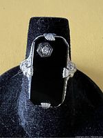 Front view showing rectangular black onyx top and hexagonal diamond accent in 14k gold filigree setting.