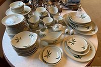 Full view of the Nunome Willow 1950s dinnerware set arranged on a table showing plates, bowls, cups, creamers, salt and pepper shakers, and serving dishes.