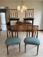 Four chairs arranged around walnut oval table in empty dining room