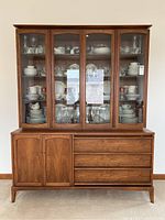 Front elevation showing entire walnut hutch with glass doors and base cabinet