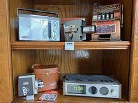 Shelf with Emerson radio, Keystone movie camera, and Nevada slot machine bank