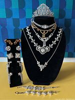 Frontal view showing all pearl necklaces displayed on bust along with tiara and earring stand.