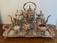 Full view of the complete vintage silver on copper coffee and tea service set including tray, coffee pot, teapot, sugar bowl, creamer, and lidded container
