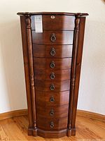 Front elevation showing curved drawers, turned columns and latch