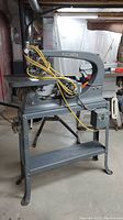 Front view of scroll saw on stand, showing table and frame