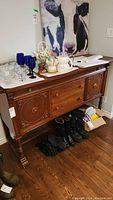 Front view of mahogany sideboard buffet with decorative carved rosettes and knobbed drawers; top surface with items